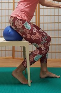 A person demonstrating the correct way to get up from a seated position.